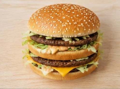 Big Mac with two beef patties, cheese, lettuce and sesame bun on a wooden board