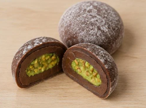 Dubai-style chocolate mochi with pistachio filling on a wooden board