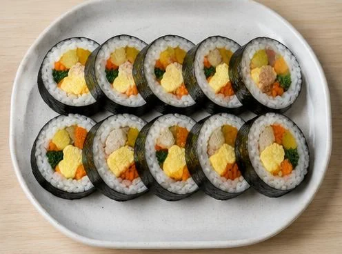 Sliced gimbap rice roll with vegetable filling on a wooden board