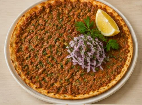 Lahmacun thin flatbread topped with spiced meat on a wooden board