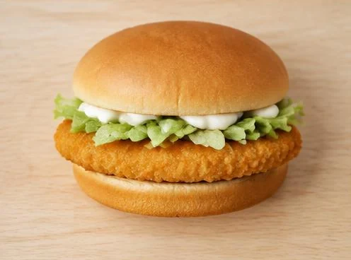 McChicken sandwich with breaded chicken and lettuce on a wooden board
