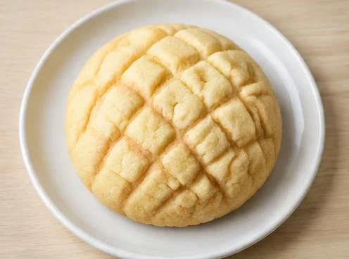 Melon pan sweet bun with crisp patterned crust on a wooden board