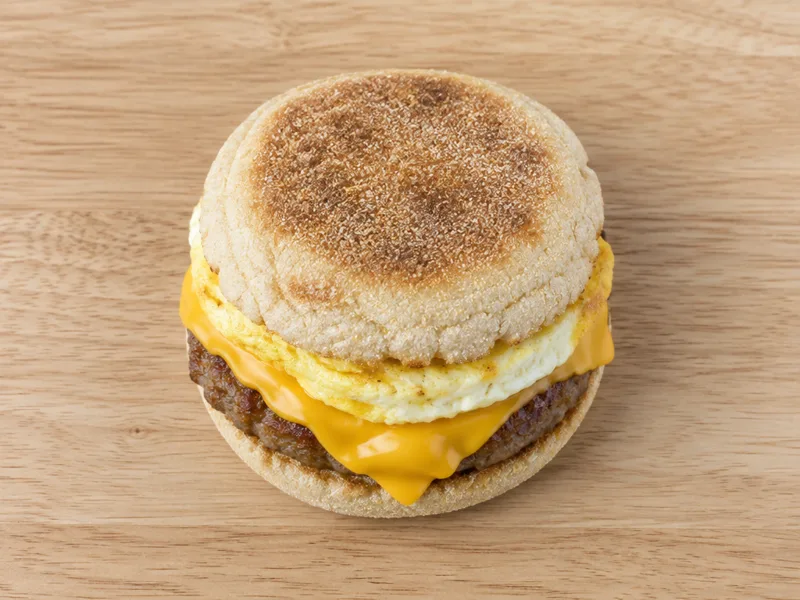 Sausage McMuffin in a toasted English muffin on a wooden board