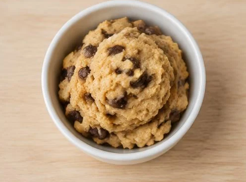 Scoop of edible cookie dough on a wooden board